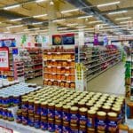 Alejka supermarketu z regałami pełnymi słoików i innych produktów