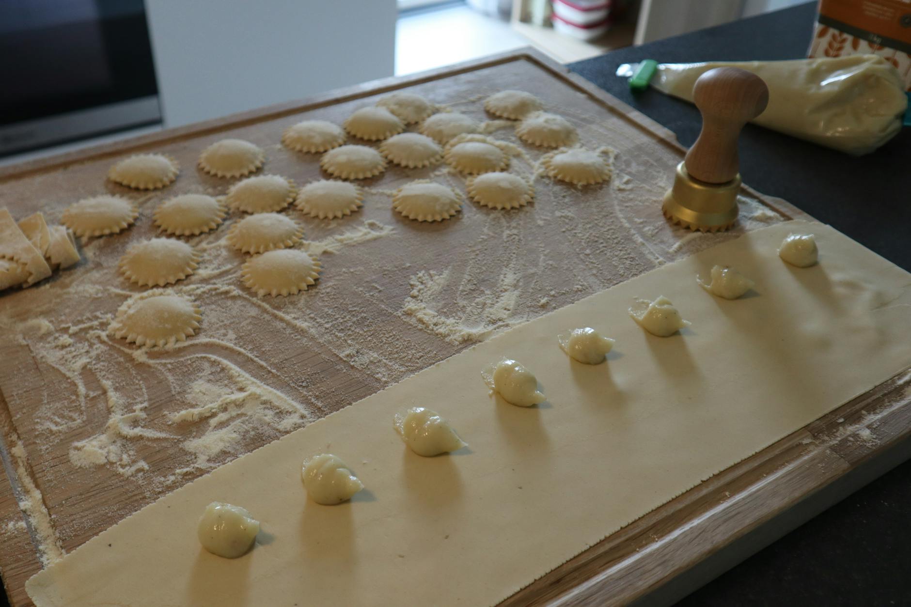 Świeże ravioli wycinane stemplem na obsypanej mąką desce