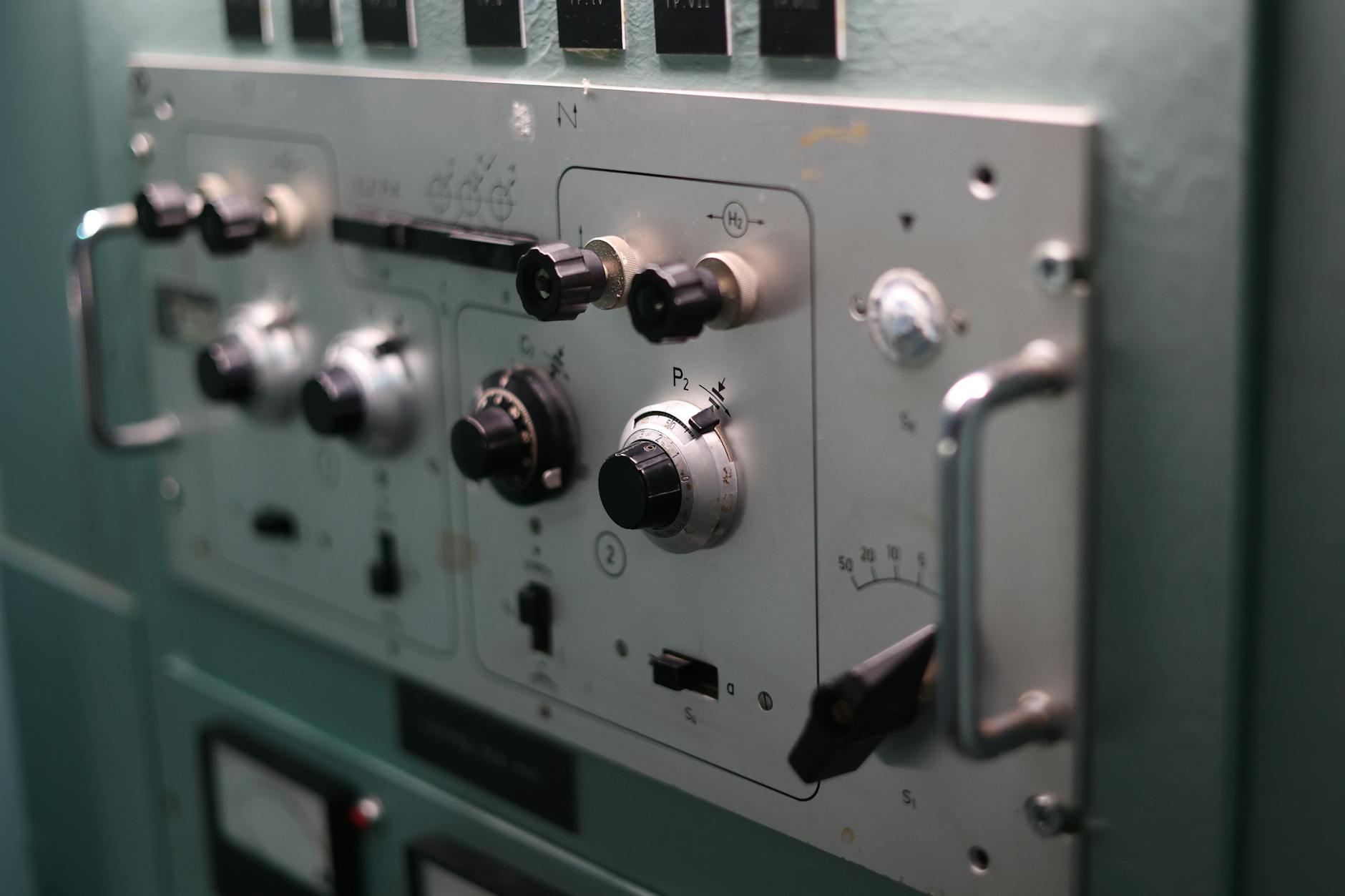 Zbliżenie panelu sterującego z przełącznikami i pokrętłami urządzenia