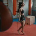 Kobieta w stroju sportowym skacze na skakance na siłowni