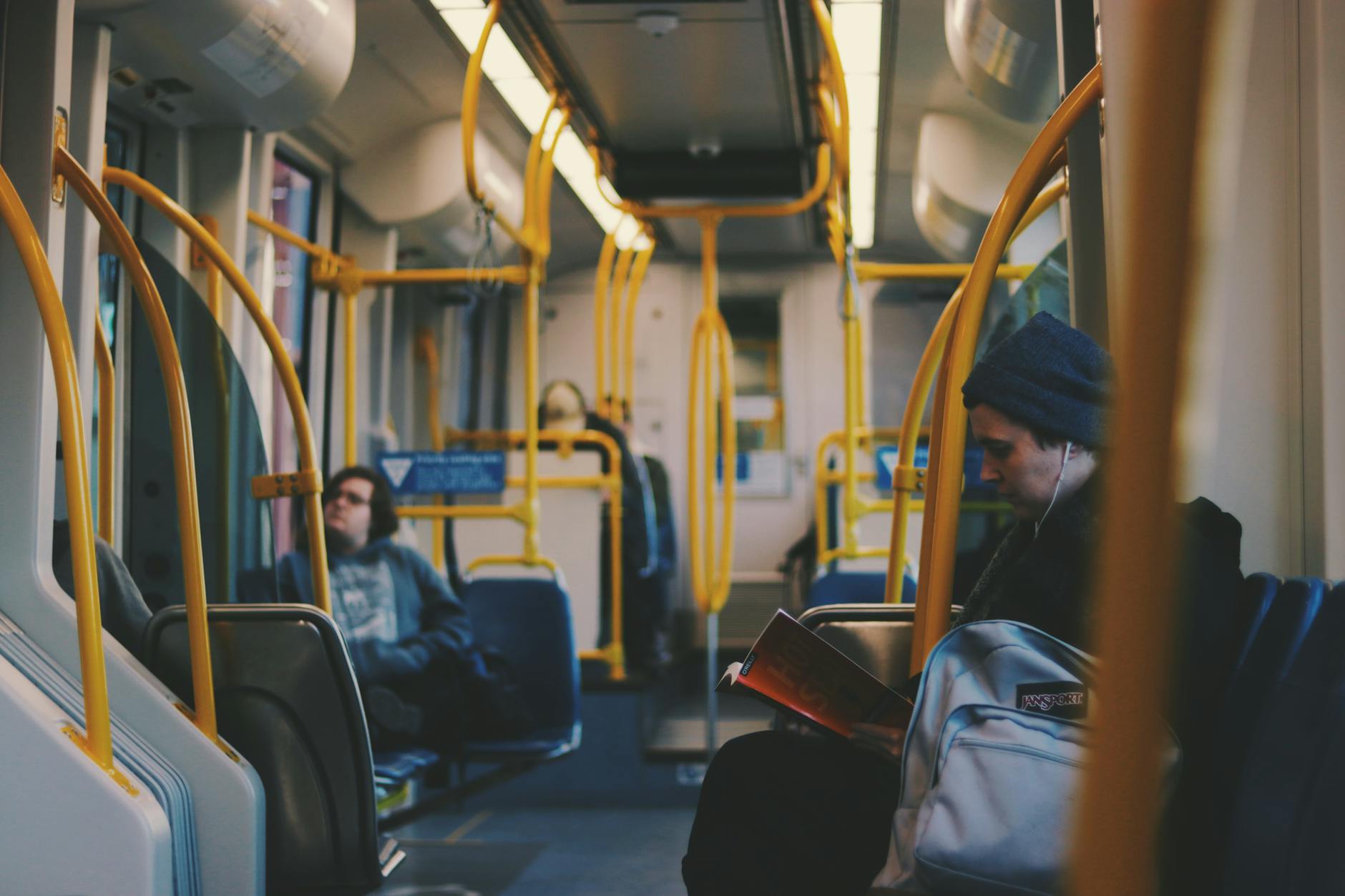Pasażerowie czytający i odpoczywający w nowoczesnym wagonie tramwaju