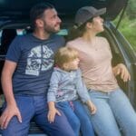 Rodzina siedzi w bagażniku samochodu podczas wyjazdu za miasto