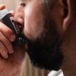 Zbliżenie mężczyzny korzystającego z inhalatora przy problemach oddechowych