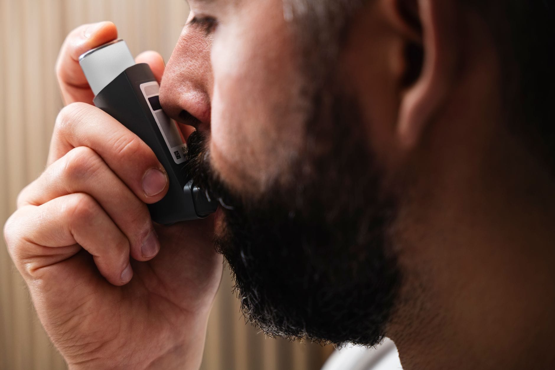 Zbliżenie mężczyzny korzystającego z inhalatora przy problemach oddechowych