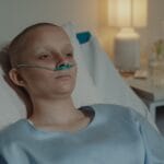 Kobieta w łóżku szpitalnym z wąsami tlenowymi